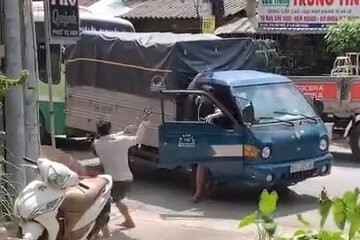 Một tài xế bỏ chạy lên xe khi bị người kia cầm gậy sắt đuổi theo tấn công (Ảnh: Cắt từ clip)