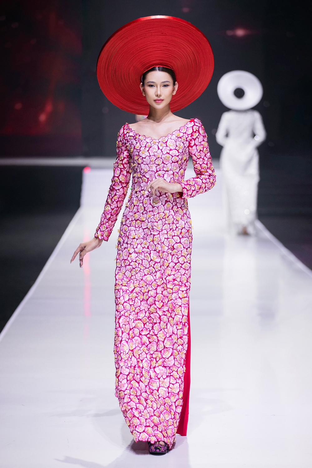 Thủy Nguyễn vẫn giữ vững phong độ sáng tạo qua thiết kế áo dài tưởng chừng quen thuộc, nay được làm mới với viền đăng ten, gợi nhắc một chút về các thiết kế của áo dài Lemur - sáng tạo của hoạ sĩ Cát Tường về việc cách tân áo dài vào thế kỷ trước.