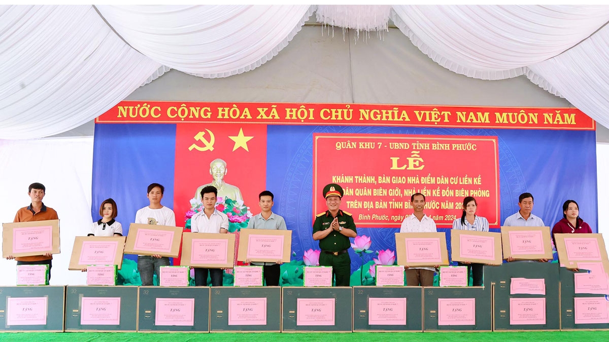 Lãnh đạo Quân khu 7 tặng quà cho các hộ gia đình được nhận nhà ở Điểm dân cư liền kề Đồn biên phòng Thanh Hòa. (Ảnh: BBP)