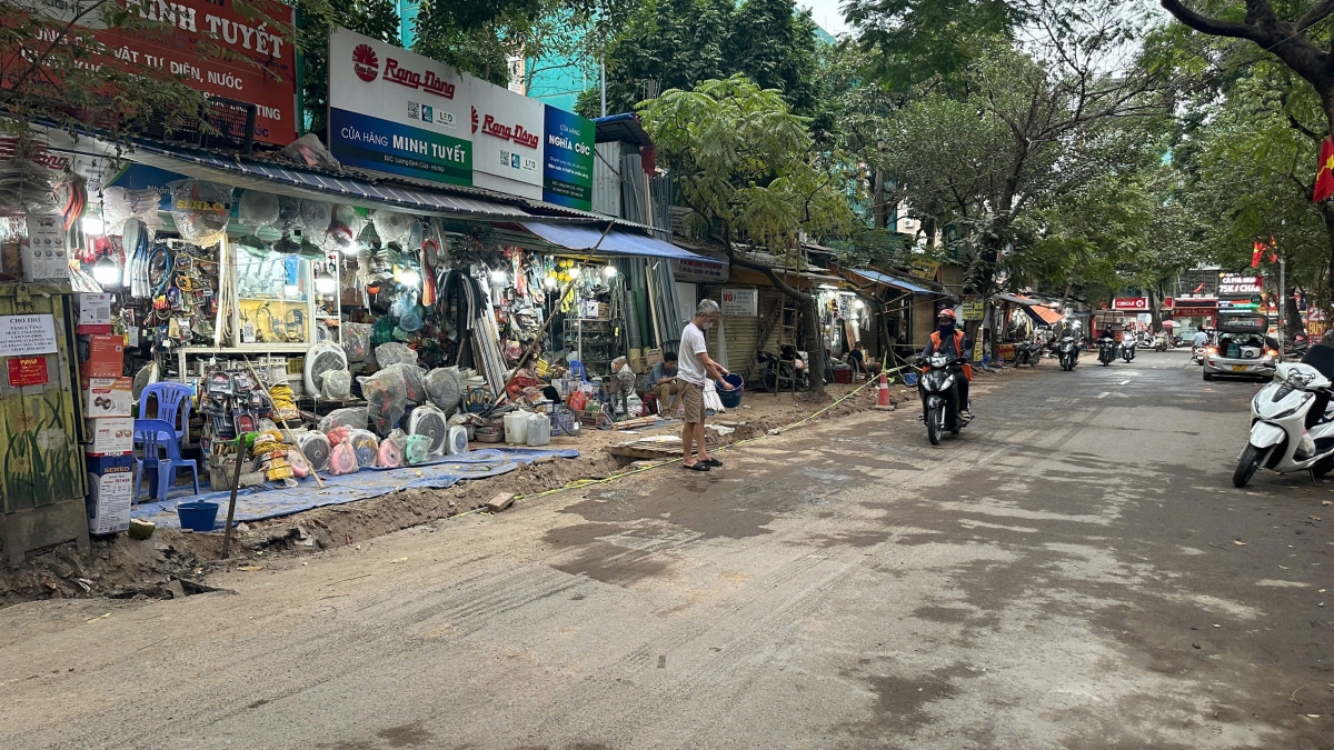 Con đường luôn trong tình trạng mịt mù bụi. Người dân phải mang nước vẩy ra đường chống bụi.