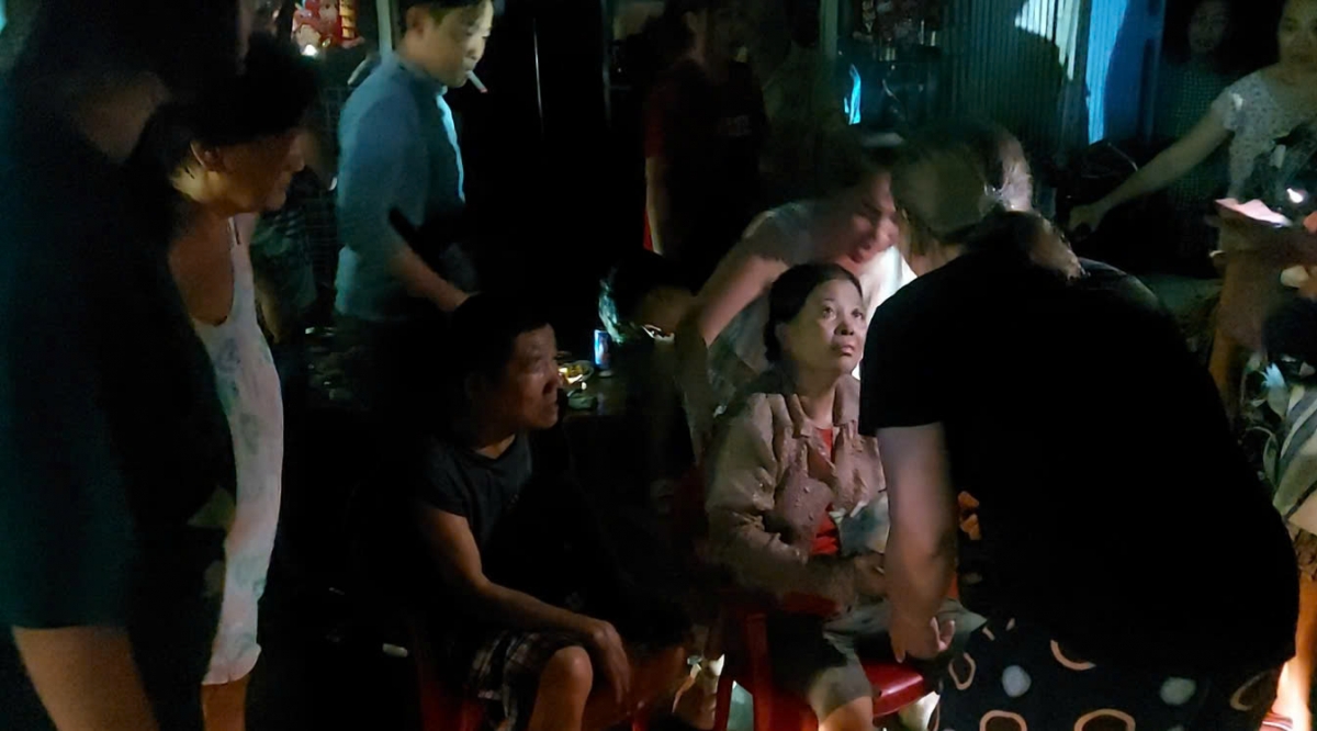 Hàng xóm thăm hỏi nạn nhân bị mắc kẹt bên trong đám cháy sau khi được đưa ra ngoài an toàn. (Ảnh: PC07)