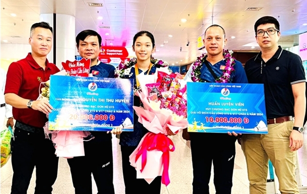 Nguyen Thị Thu Huyen (centre) is congratulated after returning home from the Badminton Asia U17&amp;U15 Junior Championships 2024 in China in August. -- Photo of Vietnam Sports Team