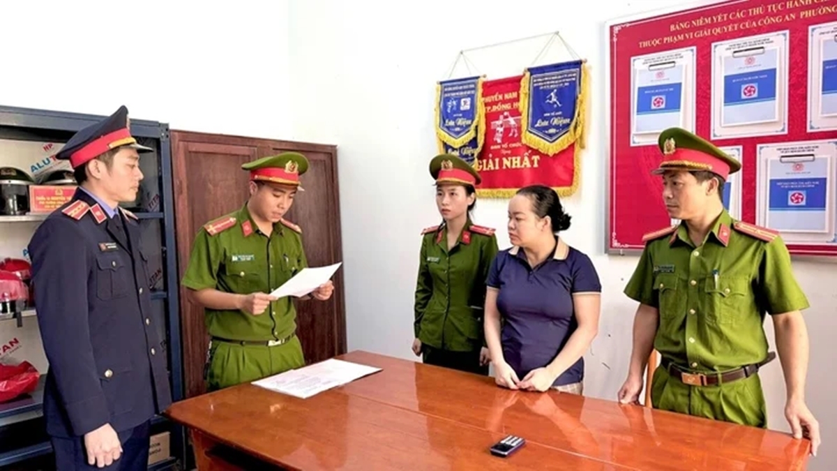 Cán bộ Cơ quan CSĐT Công an tỉnh Quảng Bình tuyên đọc các quyết định khởi tố vụ án, khởi tố bị can và lệnh cấm đi khỏi nơi cư trú với Phạm Thị Thùy Dương. (Ảnh: CA Quảng Bình)