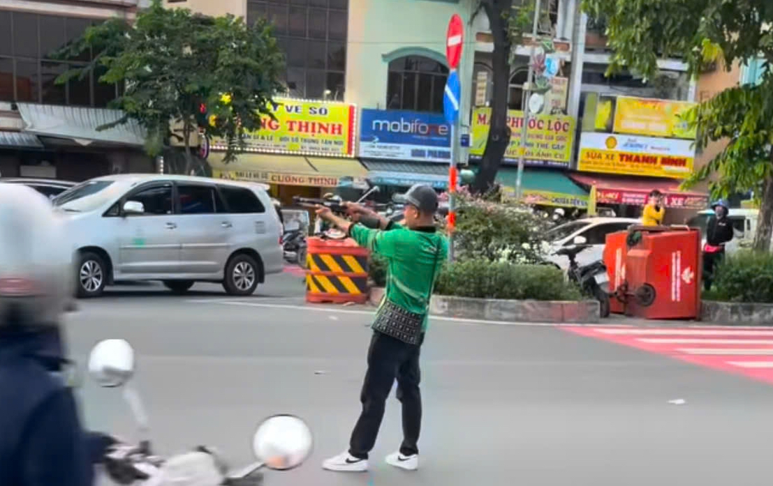 Hình ảnh nam thanh niên có biểu hiện bất thường, tay cầm vật giống súng doạ người đi đường lan truyền trên mạng xã hội (Ảnh: Cắt từ clip)