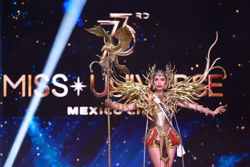 Hoa hậu Indonesia, Clara Shafira Krebs, hóa thân thành một nữ chiến binh oai hùng với bộ trang phục có phần vai ấn tượng và cây trượng đính đầu chim. Bộ trang phục lộng lẫy của cô gồm có áo nịt ngực màu vàng, quần đùi đồng bộ, họa tiết đỏ nổi bật ở hông và vật trang trí cầu vai cách điệu như đôi cánh. Điểm nhấn không thể bỏ qua chính là chiếc băng đô, được thiết kế tinh xảo, hòa hợp với các tua rua vàng rủ xuống đầy kiêu hãnh.