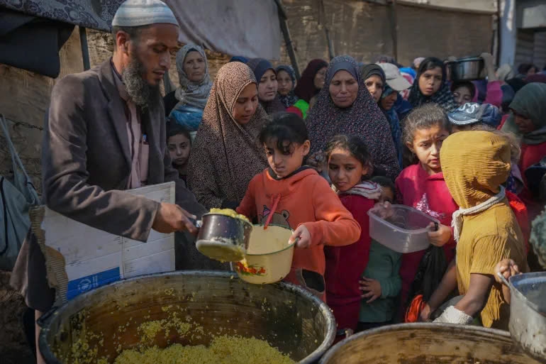 Trẻ em ở Gaza nhận thức ăn cứu trợ. (Ảnh: AP)