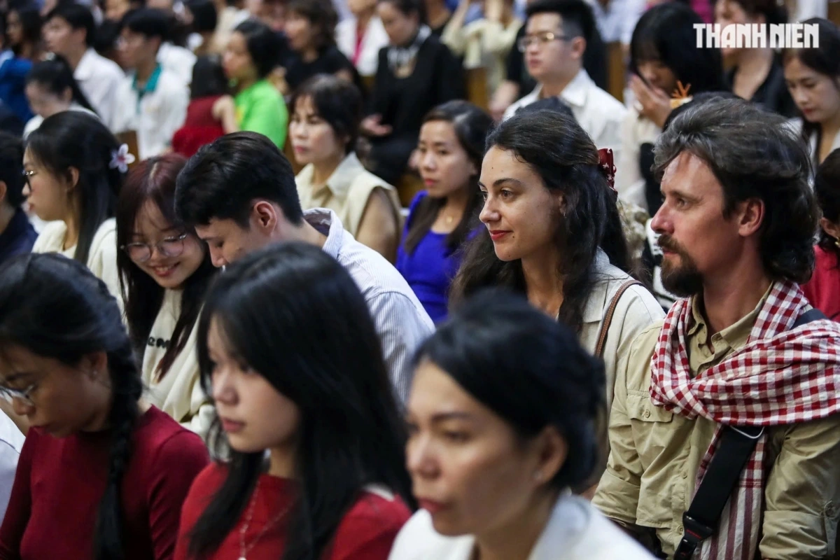 Foreign tourists attend the Mass at Notre-Dame Cathedral on the evening of December 24. (Photo: thanhnien.vn)
