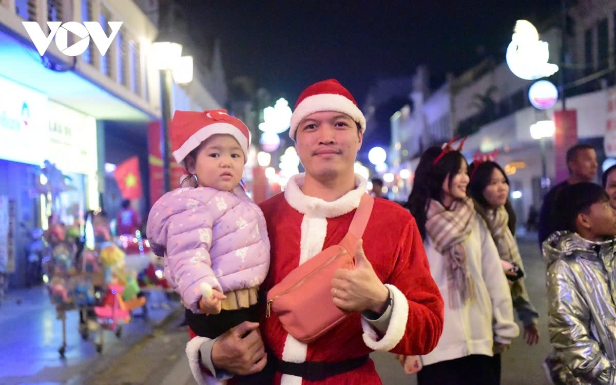 Many people, dressed in bright red Christmas outfits, bring their children to the pedestrian street to enjoy the festive Christmas atmosphere.
