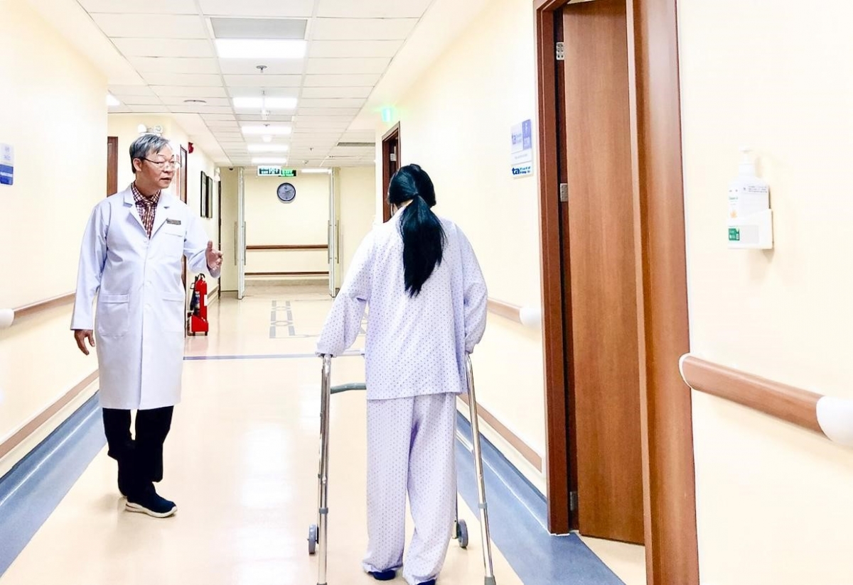 Bác sĩ Chu Tấn Sĩ hướng dẫn Linh đi lại sau ca mổ u tủy bằng Robot AI. Ảnh: Bệnh viện Đa khoa Tâm Anh TP.HCM