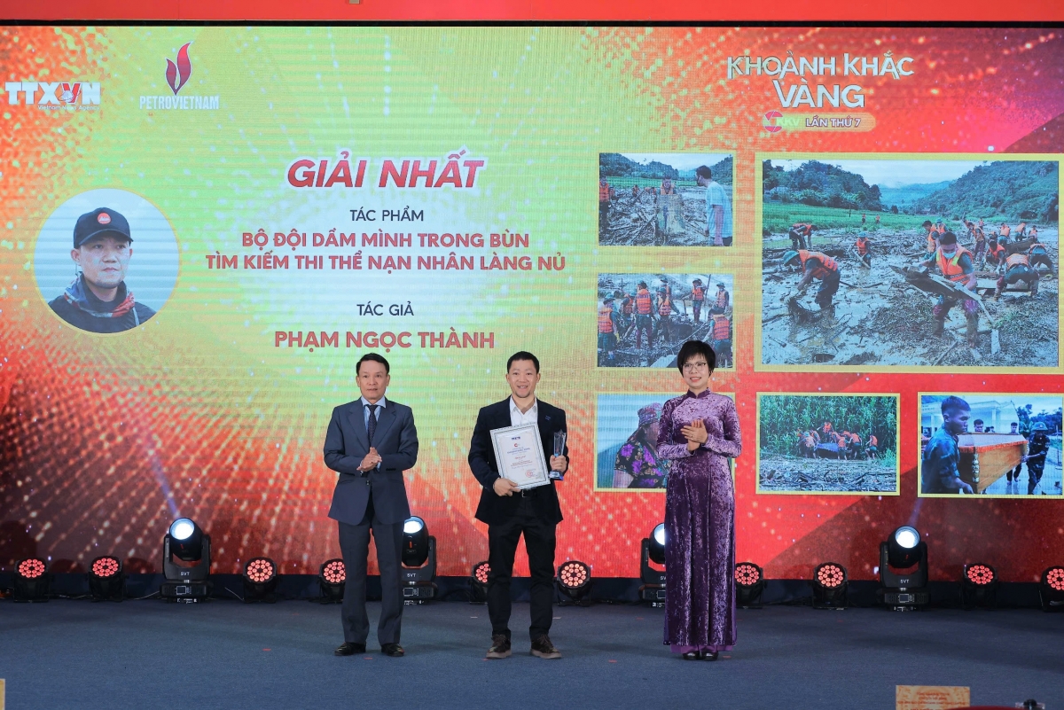 Tác giả Phạm Ngọc Thành (Hà Nội) nhận giải Nhất với tác phẩm ảnh bộ "Bộ đội dầm mình trong bùn tìm kiếm thi thể nạn nhân Làng Nủ". Ảnh: Hoàng Hiếu - TTXVN