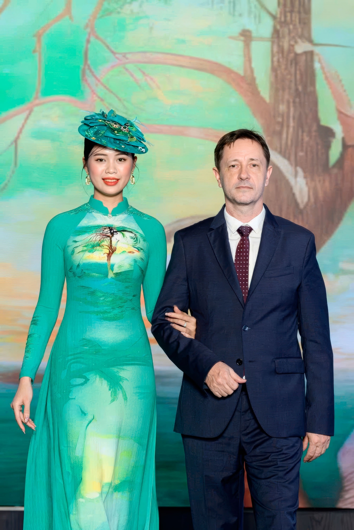 Hungarian Ambassador to Vietnam Baloghdi Tibor (R) performs with a model donning an Ao Dai featuring the “Lonely Cedar” painting by Csontvary Kostka Tivadar.