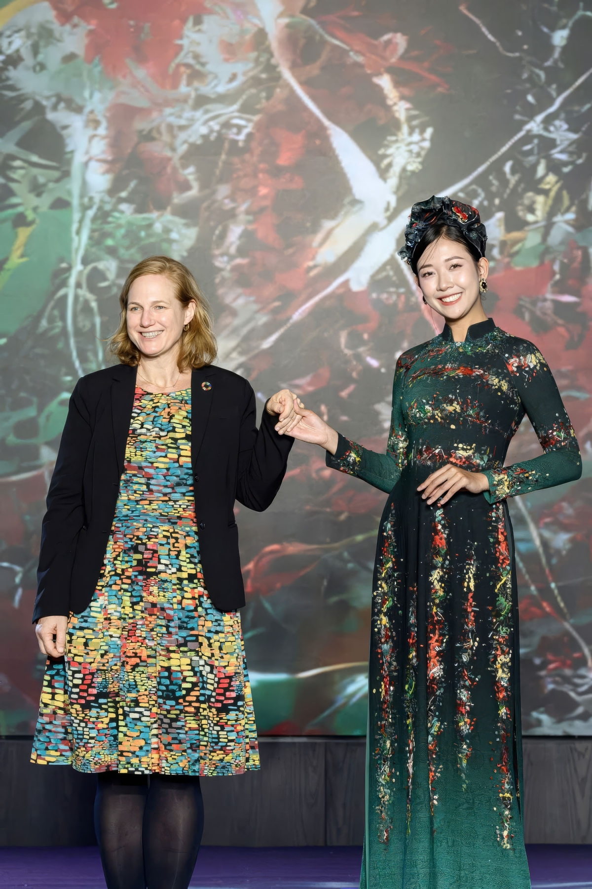 Present the event is Lynne Gadkowski, an economic counselor of the United States Embassy to Vietnam (L). The model dons an Ao Dai which takes inspiration from artworks by US painter Jackson Pollock.