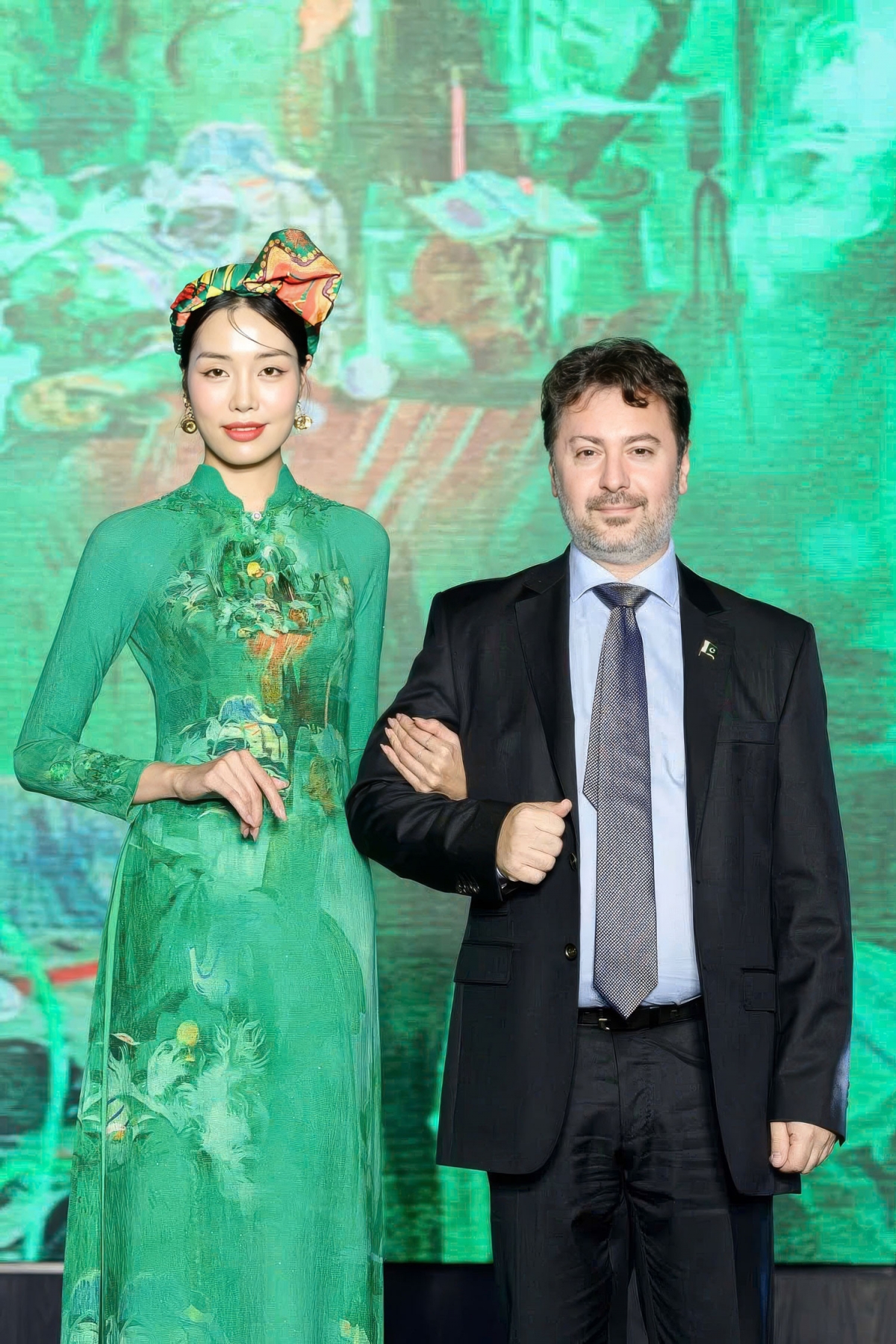 The fashion show attracts plenty of diplomats, including Pakistani Ambassador to Vietnam Kohdayar Marri (R). The model wears an Ao Dai featuring an artwork by Pakistani painter Salman Toor.