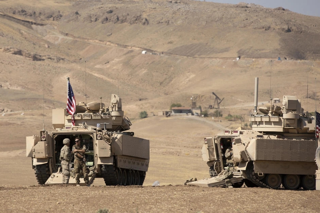 Các binh sĩ Mỹ bên cạnh xe bọc thép chở quân tại Syria (Ảnh: CBS News).