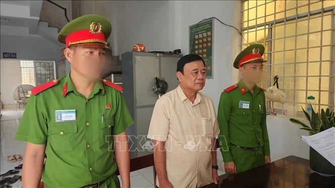 Thi hành lệnh bắt tạm giam đối với Trần Minh Vũ. (Ảnh: TTXVN phát)