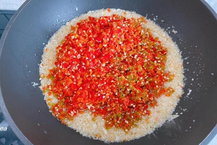 Cho ớt vào đảo đều để cạn bớt nước. (Ảnh: Sina)
