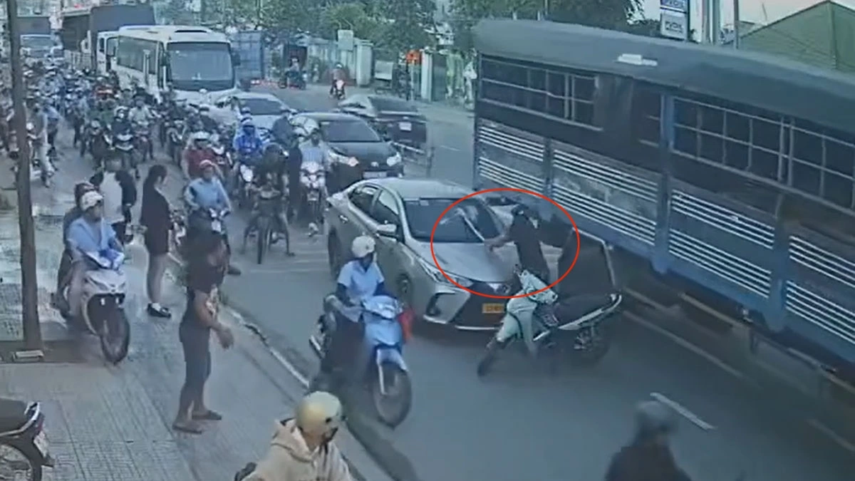 Tài xế xe máy đập kính chắn gió ô tô (ảnh cắt từ video chia sẻ MXH)