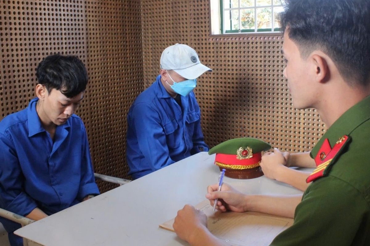 Đối tượng Đặng Duy Nam và Nguyễn Duy Hậu làm việc với công an. (Ảnh: MQ)