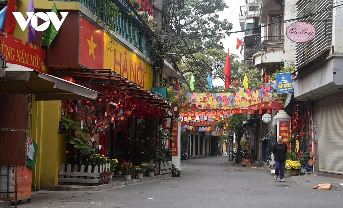 The streets are filled with the brilliant hues of blooming flowers, festive decorations, and the iconic red flags, creating a joyful and patriotic atmosphere.