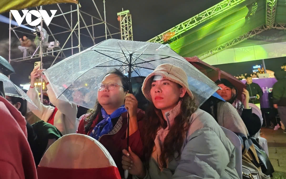 In Quy Nhon City, despite light rain, thousands of people have braved the weather with umbrellas to enjoy lively musical performances. The excitement of the 2025 New Year’s Countdown Programme has brought warmth and energy to the event.