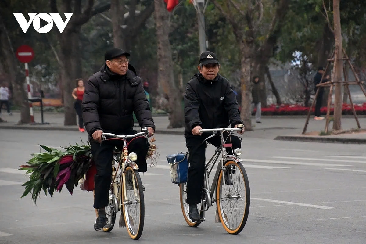 Hoan Kiem Lake, the heart of Hanoi, appears unusually serene, a stark contrast to its usual liveliness. Some senior citizens leisurely cycle around the lake, creating a serene and heartwarming scene.