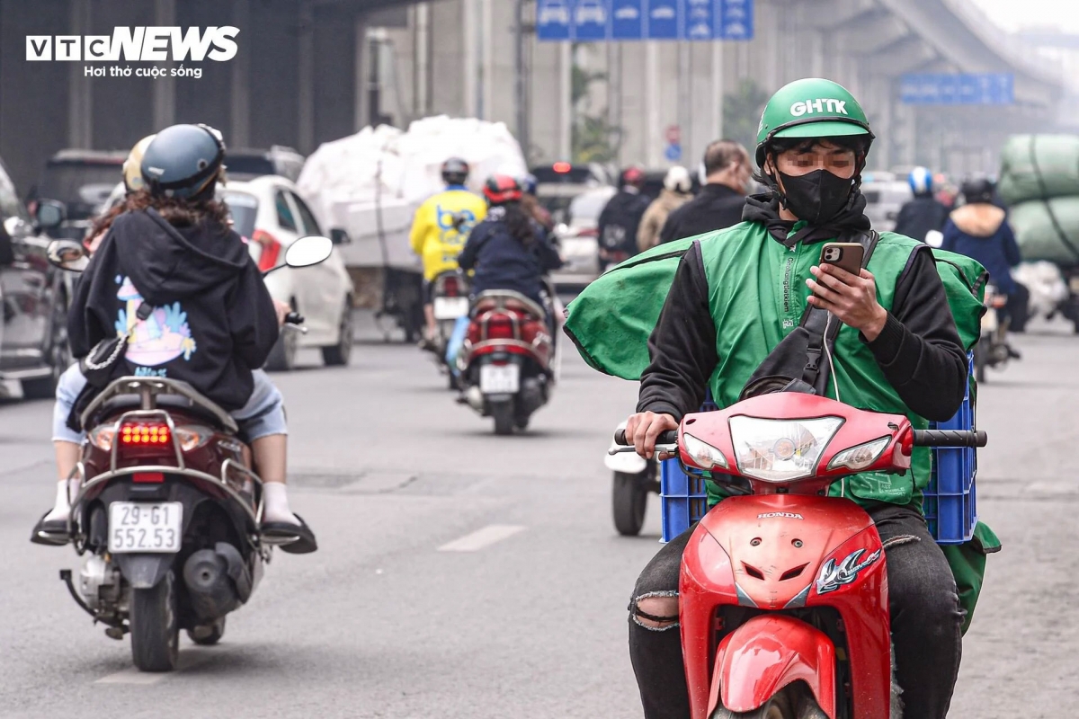 Nam shipper ngang nhiên sử dụng điện thoại khi đang lái xe máy trên đường Nguyễn Trãi, sáng 7/1.