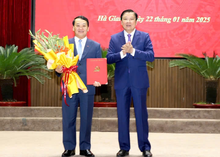 Trưởng Ban Nội chính Trung ương Phan Đình Trạc trao quyết định và tặng hoa chúc mừng ông Hầu A Lềnh.