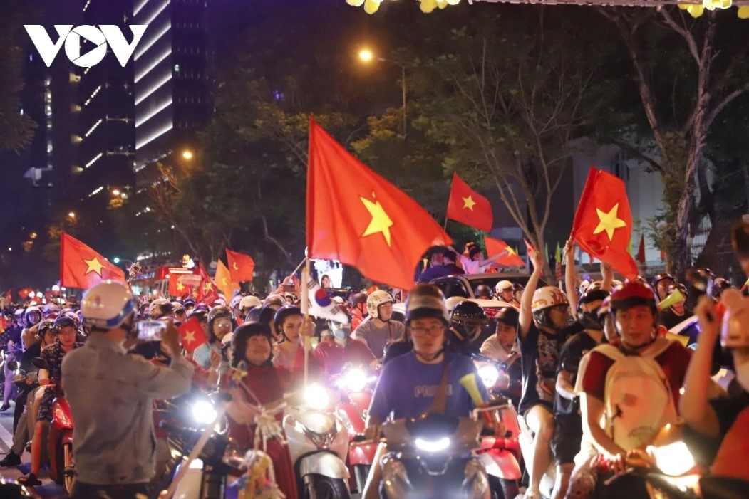 Football fans carry national flags and sing joyful songs to mark the national team’s historic victory at the ASEAN Cup.