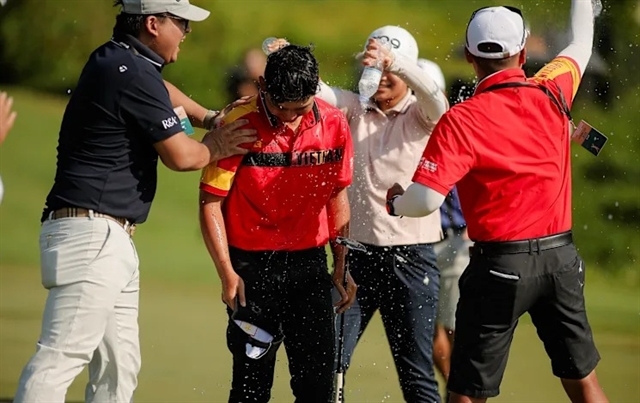 Nguyen Anh Minh of Vietnam is doused in water and congratulated by Vietnam Golf Association Secretary-General Vu Nguyen (left) after he wins Nomura Cup's individial title and helps Vietnam take the team top place last October. (Photo of VGA)