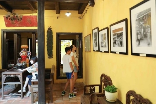 Tourists view photos exhibited in the heritage house on 87 Ma May street, Hanoi.
