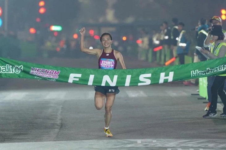 Nguyen Thi Oanh crosses the finish line in a new national record time for the women's 21km category in the Vietnam International Half Marathon 2025 powered by Herbalife on January 1 in Hanoi. (Photo: VIHM)