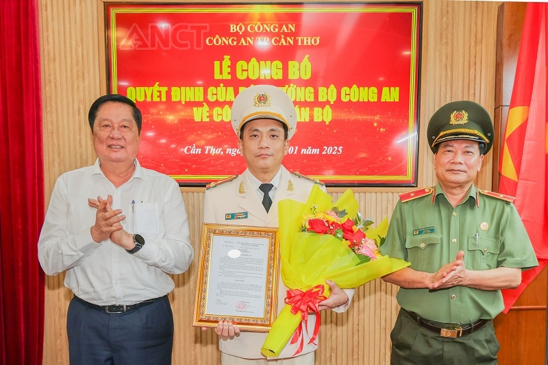 Ông Phạm Văn Hiểu và Thiếu tướng Nguyễn Văn Thuận trao quyết định và tặng hoa chúc mừng Thượng tá Hà Bảo Huy (Ảnh Công an)