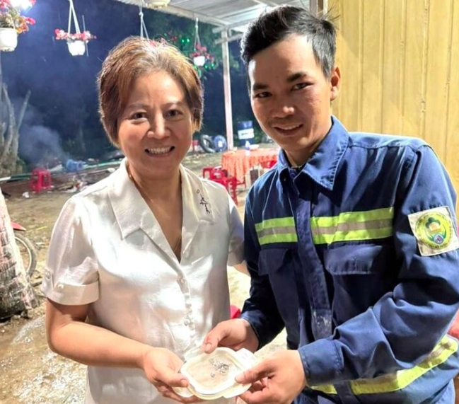 Công nhân Công ty CP Môi trường đô thị Đà Nẵng trao tra túi chứa nhẫn đính kim cương cho bà Hoa.