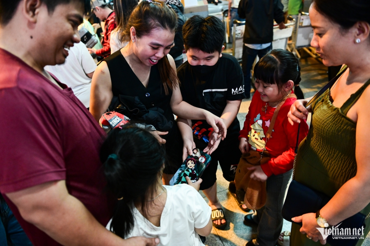 Children show happiness at receiving gifts from their older sister returning from Taiwan (China).