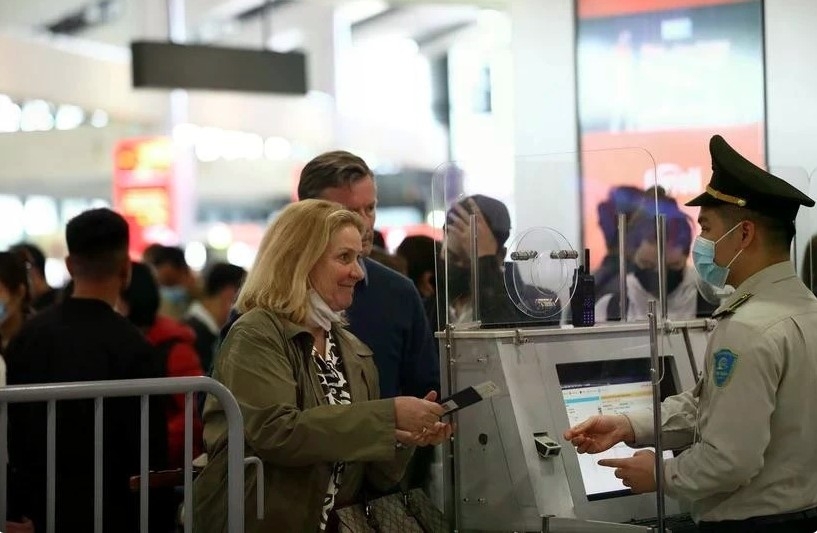 Aviation security staff verify passenger information before security screening at an airport in Vietnam.