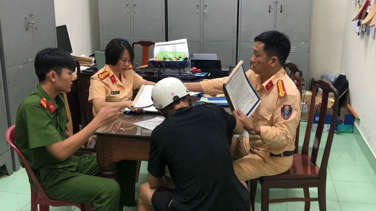 Lực lượng chức năng lập biên bản xử phạt nam thanh niên chạy xe máy bằng một bánh (Ảnh: CA)