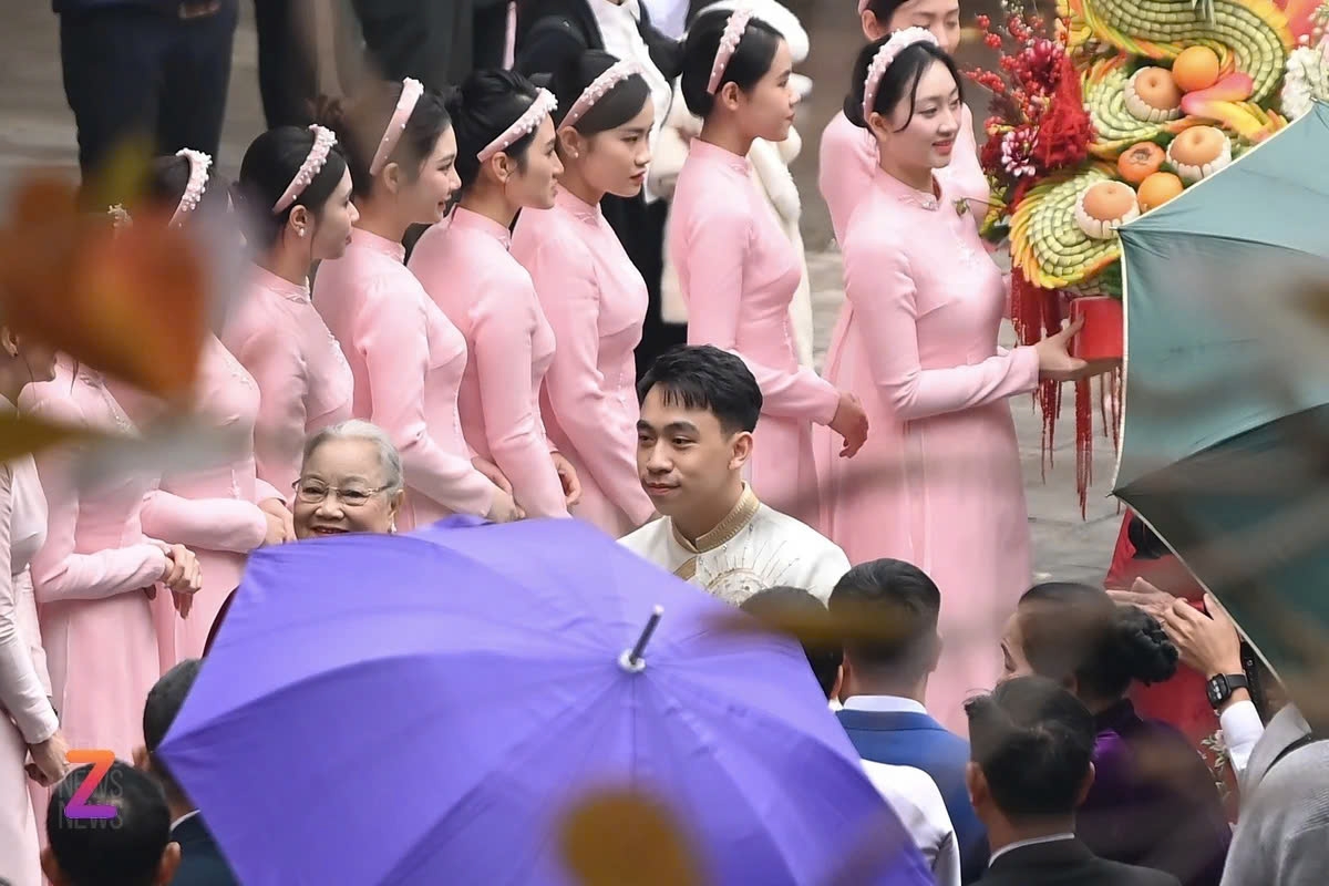 Đúng 8h, chú rể cùng đoàn nhà trai xuất hiện. Khi chú rể Phạm Nhật Minh Hoàng vừa bước vào cửa, đội ngũ vệ sĩ có mặt sẵn, dùng dù tím che chắn kỹ lưỡng. Chồng Phương Nhi sinh năm 2000, là con trai thứ hai của tỷ phú Phạm Nhật Vượng, có cuộc sống kín đáo. Anh hiện là tổng giám đốc của một công ty kinh doanh xe. (Ảnh: ZNews)