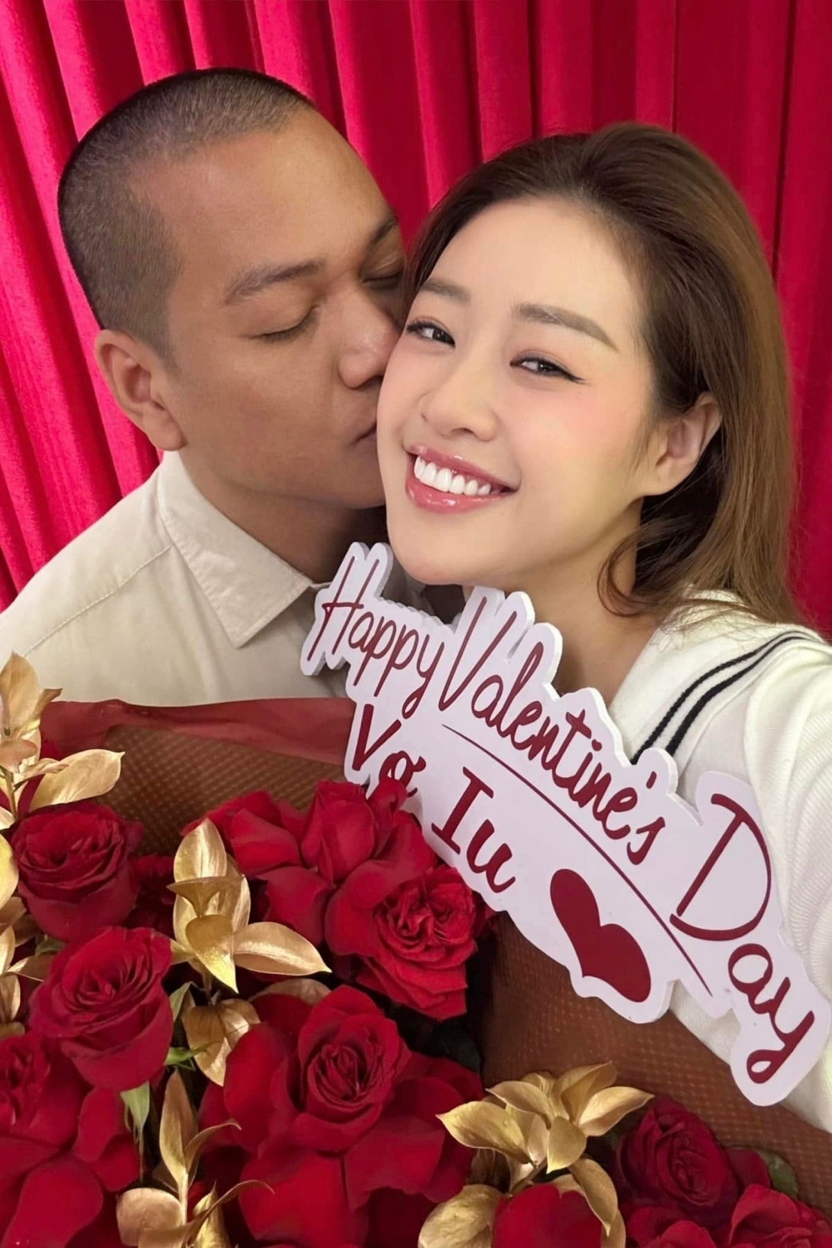 Hoa hậu Khánh Vân khoe được ông xã Nguyễn Long hôn má, tặng bó hoa hồng lớn có dòng chữ “Happy Valentine's Day vợ iu”.