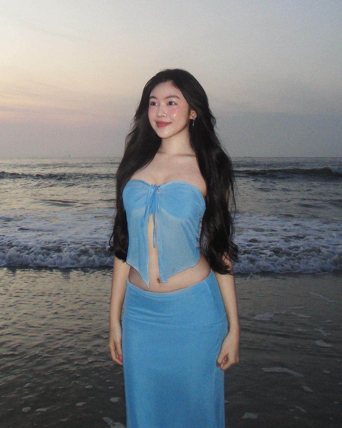 Lọ Lem khoe dáng khi đi biển dưới ống kính của bố Quyền Linh. Người đẹp 19 tuổi tôn thân hình gợi cảm với bộ đầm gồm áo bra top và chân váy cạp trễ, làm từ chất liệu thun siêu mỏng.