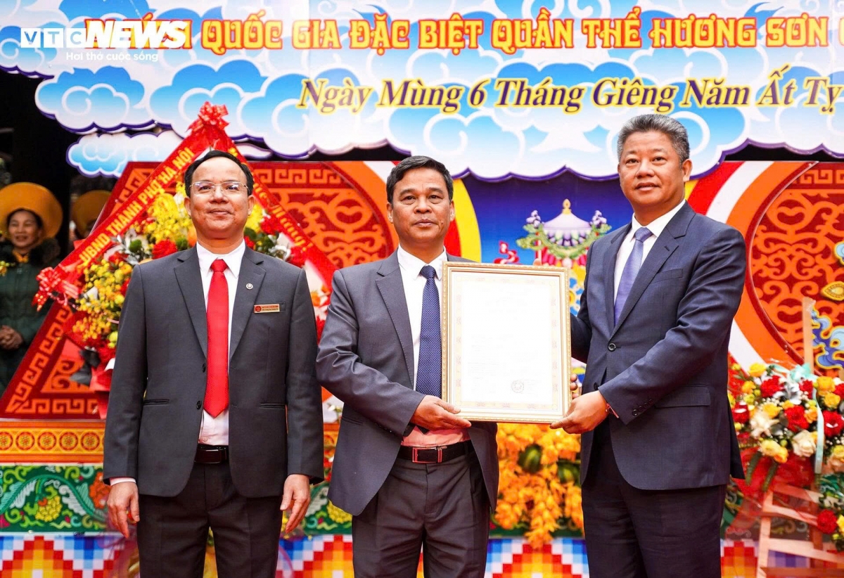 Vice Chairman of the Hanoi People’s Committee Nguyen Manh Quyen (right) presents the municipal administration’s decision to recognize the city-level tourist area for the Huong Son complex special national relic.