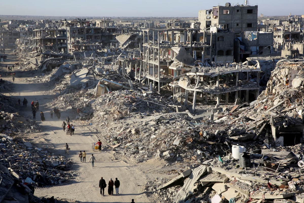 Người dân Palestine đi ngang qua đống đổ nát của những ngôi nhà và tòa nhà bị phá hủy trong chiến tranh, ở Rafah, phía nam Dải Gaza, ngày 20/1. Ảnh: Reuters