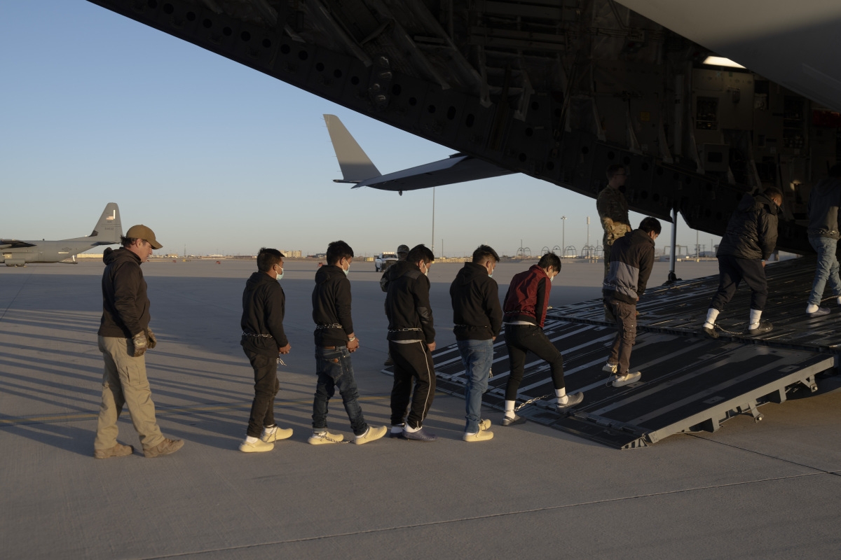 Đặc vụ thuộc Cơ quan Hải quan và Biên phòng Mỹ (CBP) áp giải người nhập cư trái phép lên vận tải cơ C-17 ở Fort Bliss. Ảnh: Reuters