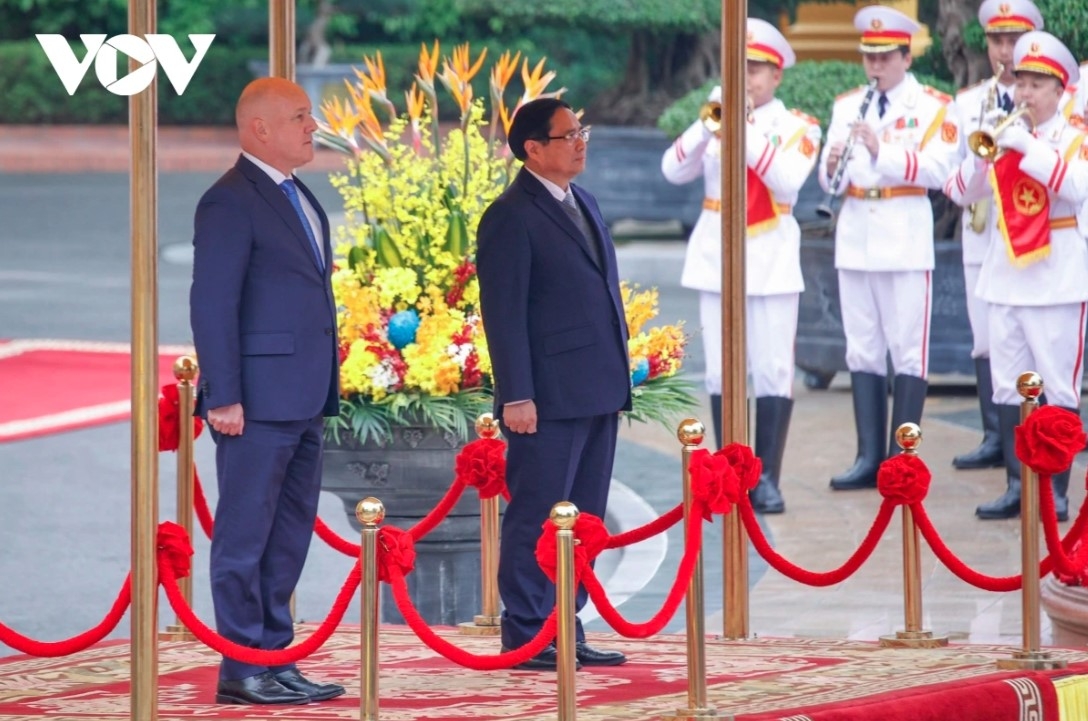 Prime Minister Pham Minh Chinh and his New Zealand counterpart Christopher Luxon stand on the podium while military bands play the national anthems of both nations.