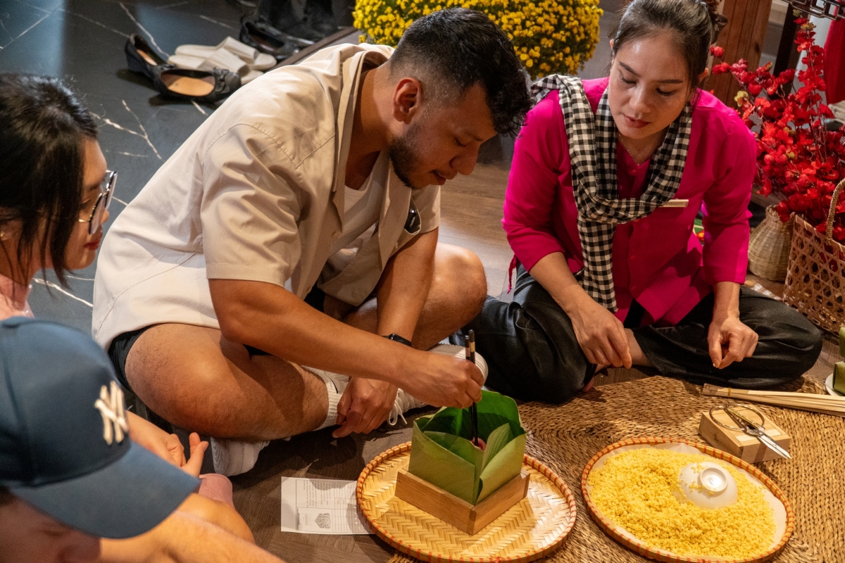 Hoạt động trải nghiệm gói bánh chưng và tìm hiểu mâm cỗ ngày Tết được nhiều vị khách quốc tế hưởng ứng.