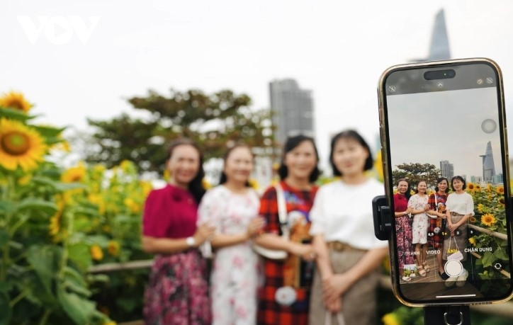 Ho Chi Minh City landmarks, such as the Bitexco building and Thu Thiem 2 bridge, can be seen behind the sunflower field, creating beautiful corners that many people choose for check-in photos.