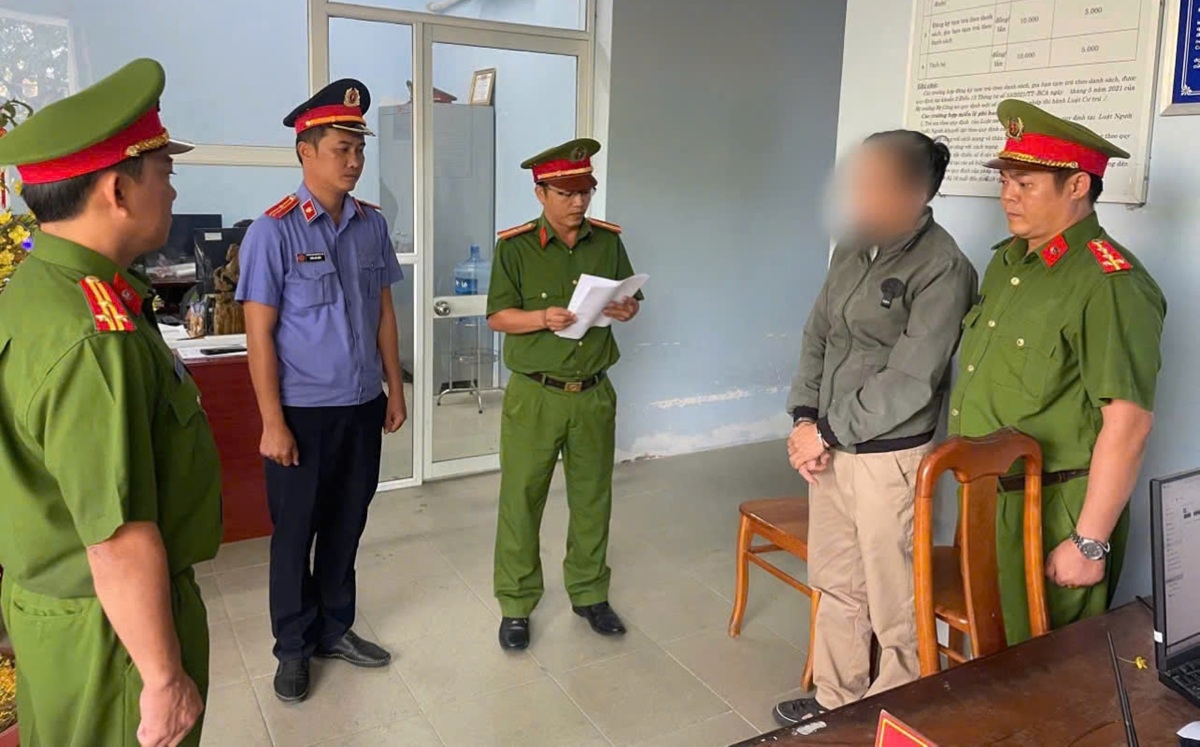 Lực lượng chức năng đọc quyết định khởi tố, lệnh tạm giam (Ảnh: B.H) 