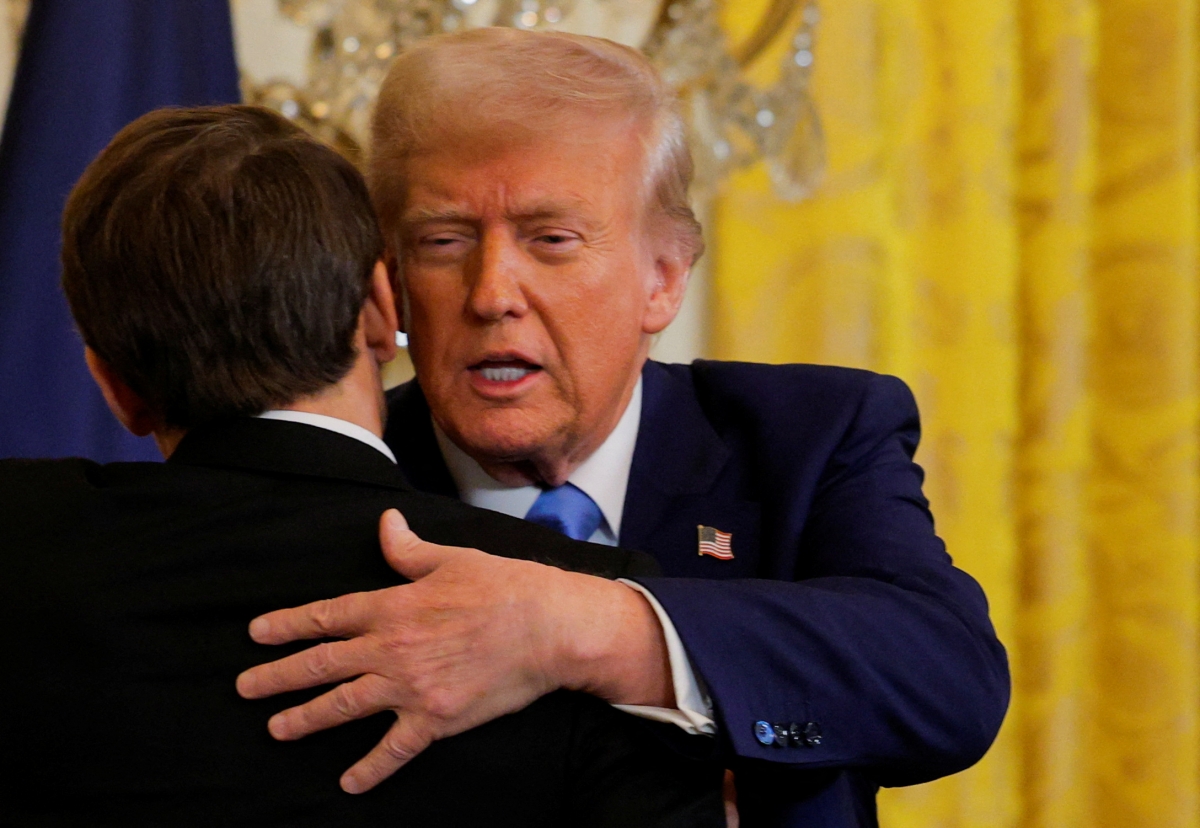 Tổng thống Mỹ Donald Trump ôm Tổng thống Pháp Emmanuel Macron sau cuộc họp báo ở Nhà Trắng hôm 24/2. Ảnh: Reuters.