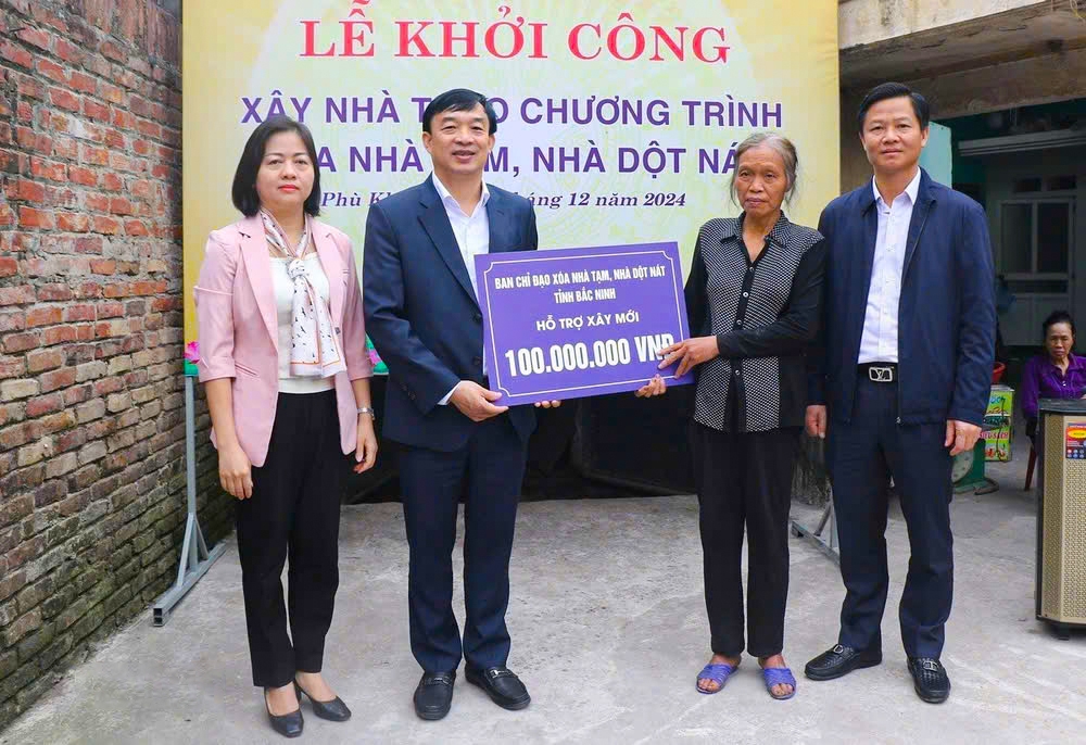 Bà Ngô Thị Sơn (thứ 2 từ phải), khu phố Phù Khê Thượng, phường Phù Khê, thành phố Từ Sơn, tỉnh Bắc Ninh nhận hỗ trợ xây nhà mới từ tỉnh Bắc Ninh