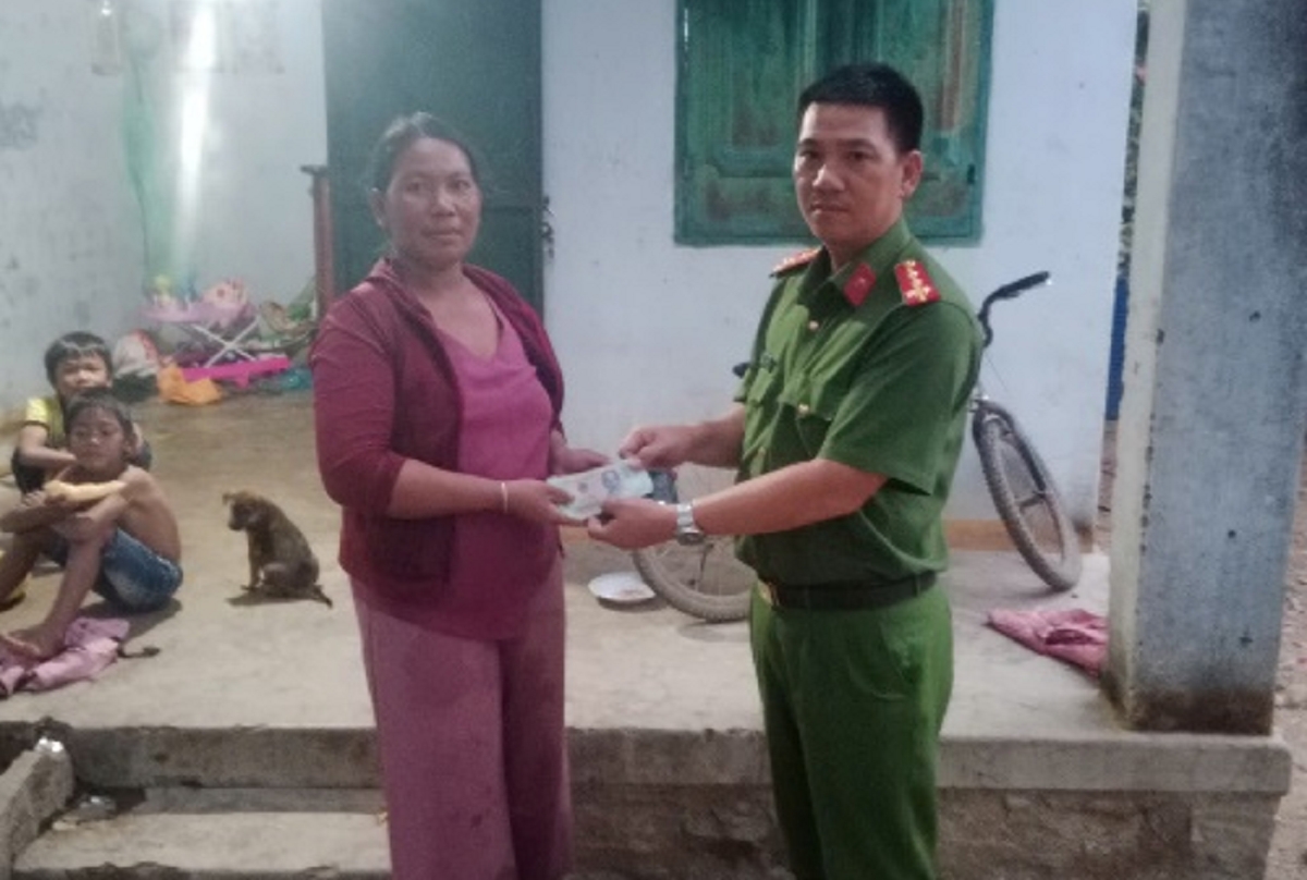 Đại uý Lê Văn Biên trao trả tài sản bị mất cho chị Katơr Thị Hính. Ảnh: CANT