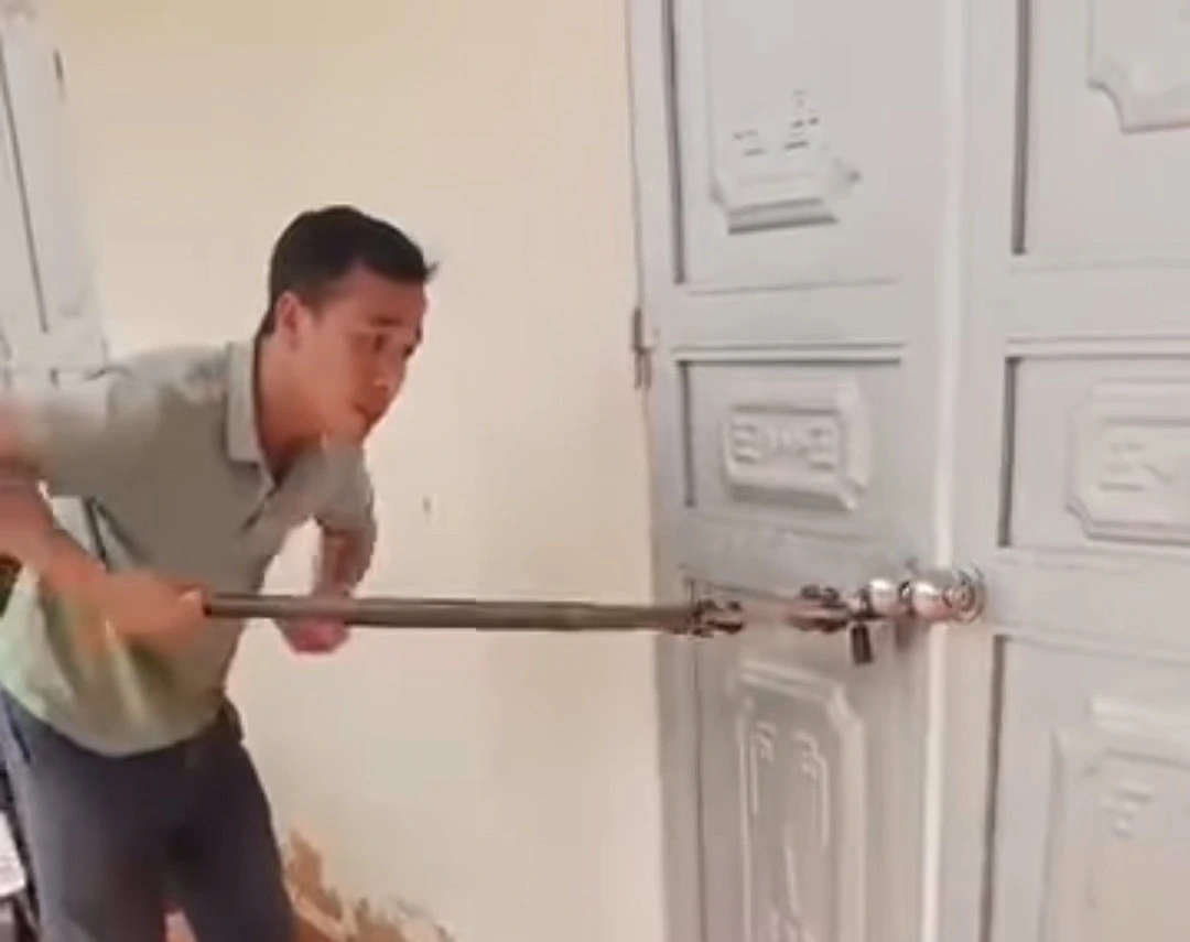 Phụ huynh dùng kìm phá khóa đưa học sinh bị bỏ quên trong lớp học ra ngoài. Ảnh: XĐ